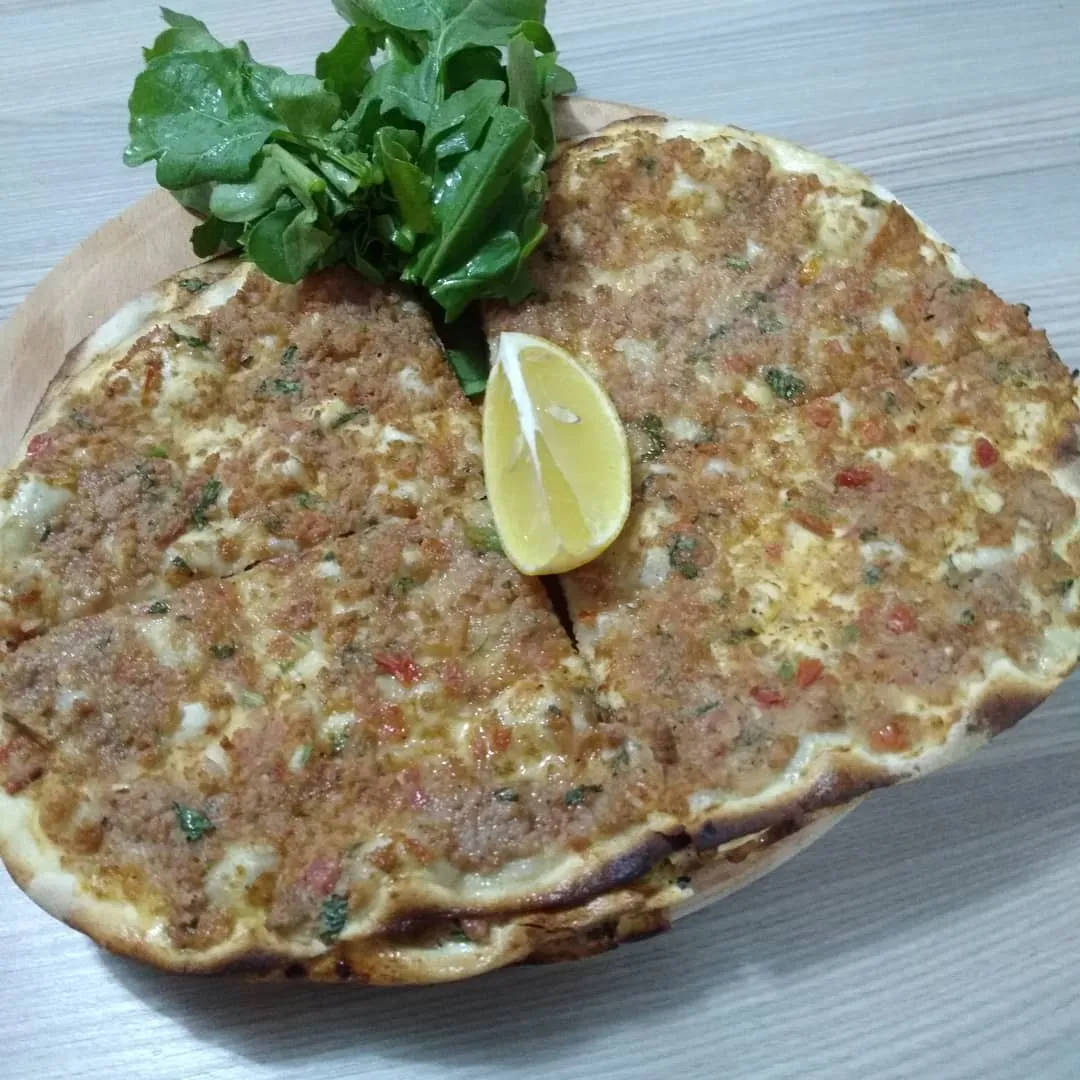 Tahta üstünde limon ve rokayla lahmacun