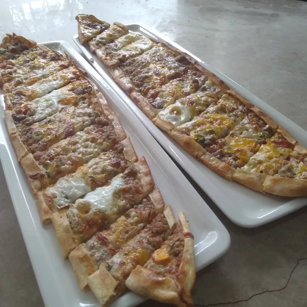 İki uzun tabakta dilimlenmiş kıymalı ve kaşarlı pide