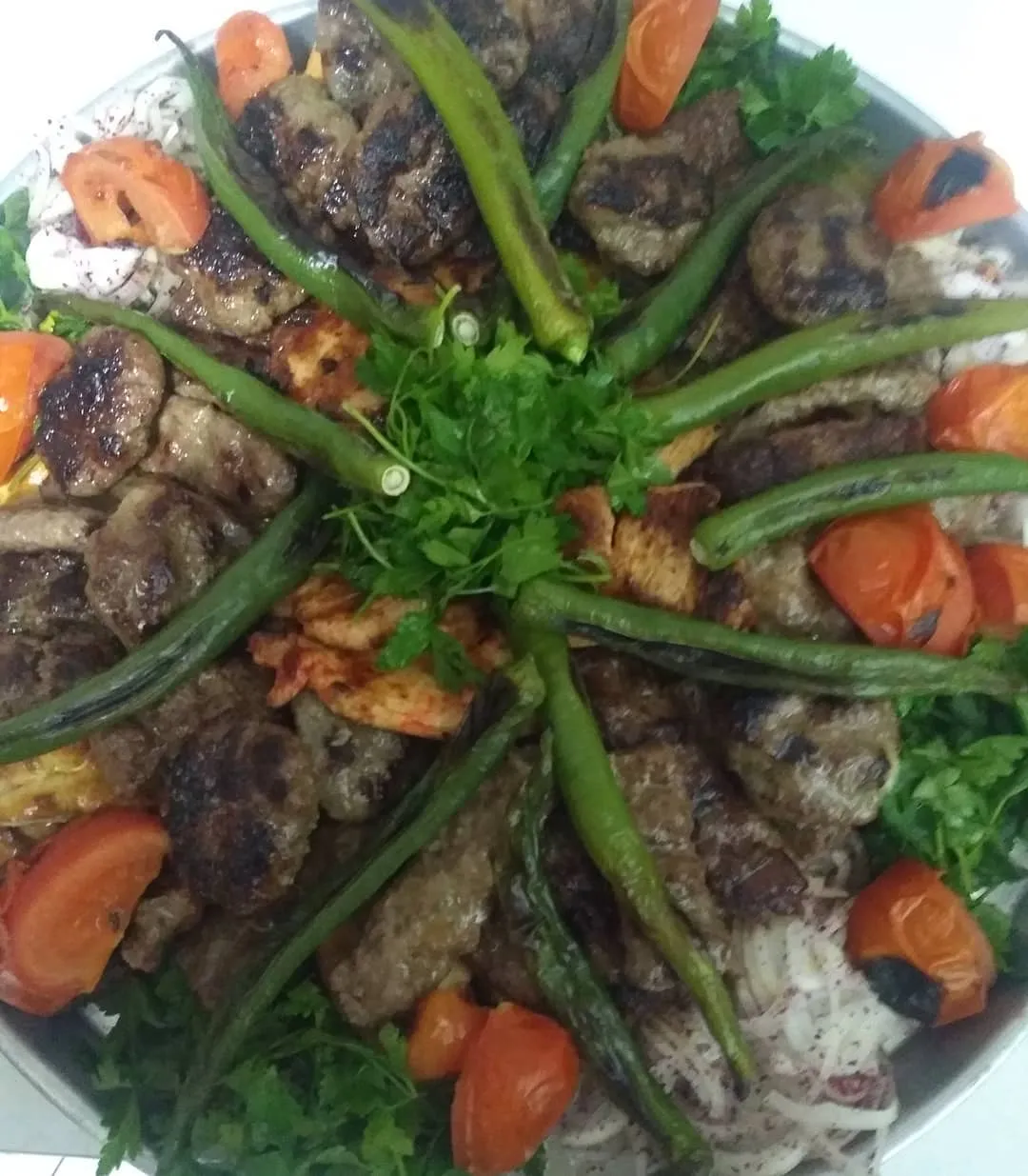 Bakır tepside köfte, tavuk, köz biber ve maydanozla tepsi kebap